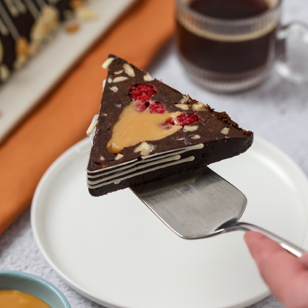 Postre de chocolate decorado con almendras y chocolate blanco. Opción con frambuesa