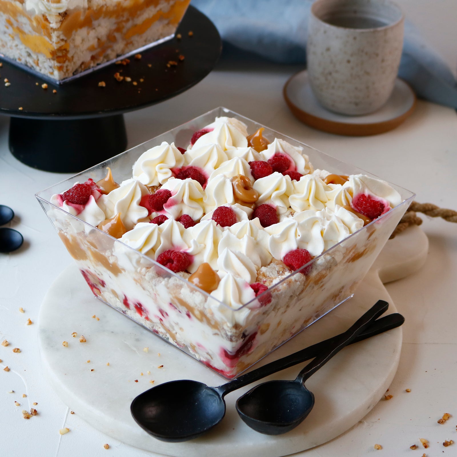 Postre con merengue, almendras acarameladas, manjar y crema, opción frambuesa, lúcuma o castaña