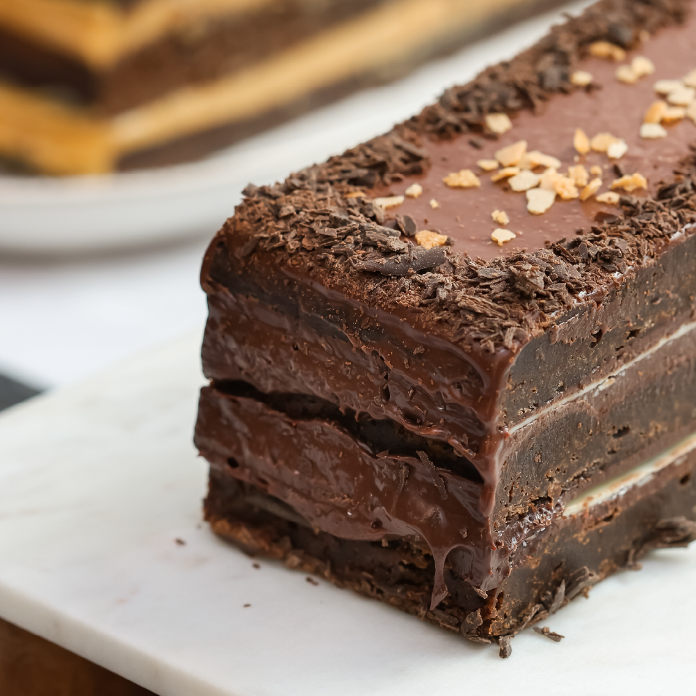 Torta de chocolate estilo brownie con ganache y láminas de chocolate blanco