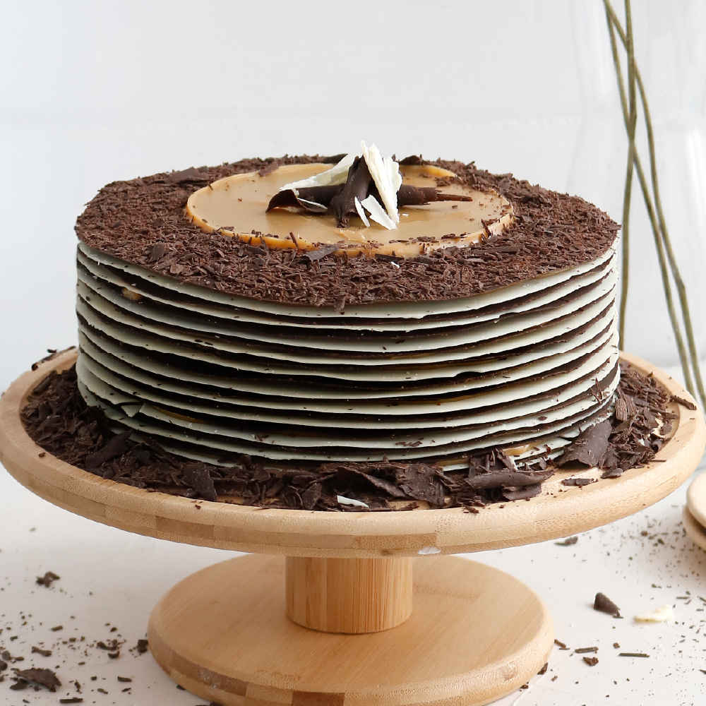 Torta congelada con láminas de chocolate blanco y bitter rellenas con manjar blanco